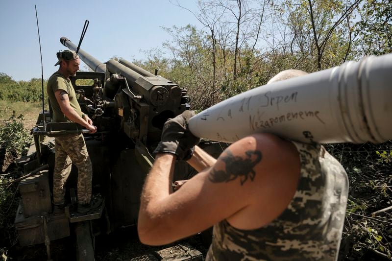 In this photo provided by Ukraine's 24th Mechanised Brigade press service, servicemen of the 24th Mechanised Brigade prepare to fire a" Giatsint-S" 152mm self-propelled howitzer towards Russian positions near Chasiv Yar town, in Donetsk region, Ukraine, Tuesday, Aug. 20, 2024. Writing on the shell reads "Irpin. Will not forgive". (Oleg Petrasiuk/Ukrainian 24th Mechanised Brigade via AP)