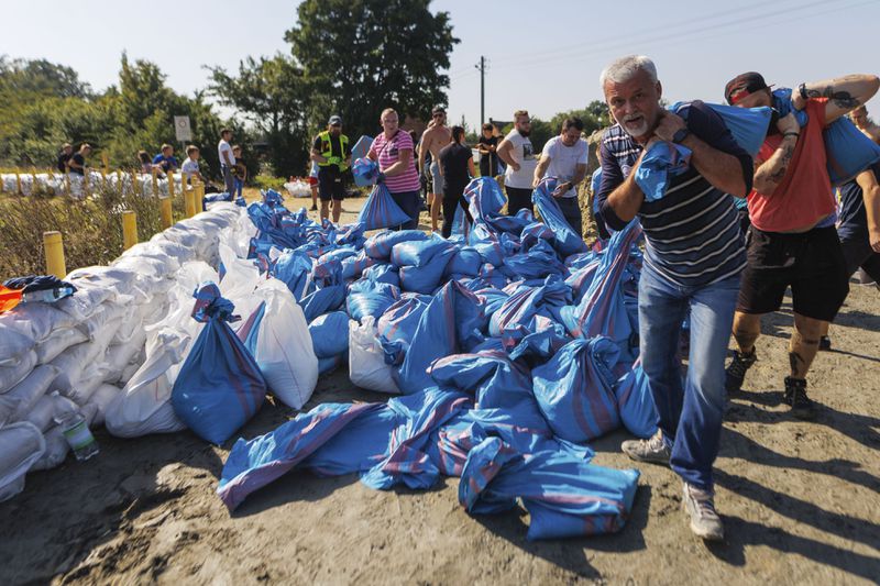 Residents use sandbags to strengthen the embankment of the Oder River on its way to Wroclaw, southwestern Poland, Tuesday, Sept. 17, 2024. (AP Photo/Krzysztof Zatycki)