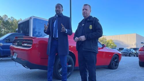 Atlanta police Interim Chief Darin Schierbaum (right) and Mayor Andre Dickens stand in front of an impounded Dodge Challenger on Tuesday morning and warn street racers to stay out of the city or face the consequences.