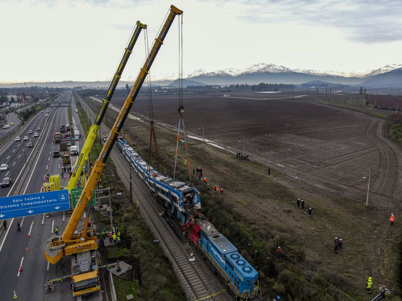 Cranes remove part of a train that collided with another in San Bernardo, Santiago, Chile, Thursday, June 20, 2024. (AP Photo/Esteban Felix)