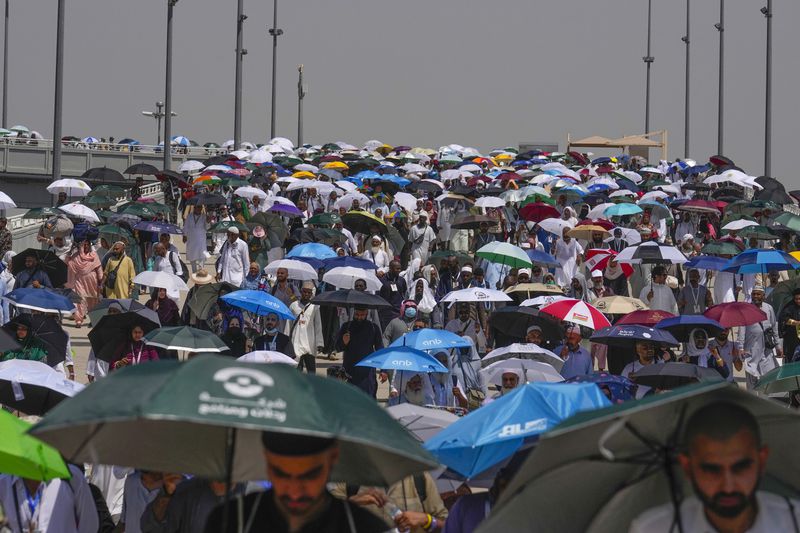 FILE - Muslim pilgrims use umbrellas to shield themselves from the sun as they arrive to cast stones at pillars in the symbolic stoning of the devil, the last rite of the annual hajj, in Mina, near the holy city of Mecca, Saudi Arabia, Tuesday, June 18, 2024. More than 1,000 people died during this year’s Hajj pilgrimage in Saudi Arabia as the faithful faced extreme high temperatures at Islamic holy sites in the desert kingdom, officials said Sunday, June 23, 2024. (AP Photo/Rafiq Maqbool)