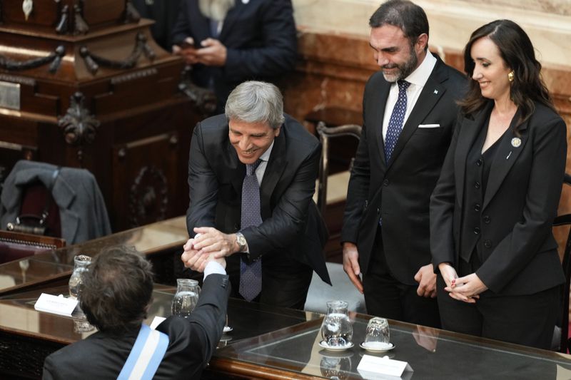 Argentina's Economy Minister Luis Caputo, second from left, greets Argentina's President Javier Milei upon as he arrives at Congress to present the 2025 budget in Buenos Aires, Argentina, Sunday, Sept. 15, 2024. (AP Photo/Natacha Pisarenko)