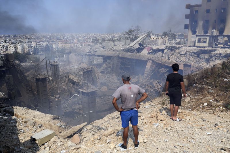 People check a damaged building at the site of an Israeli airstrike in Choueifat, south east of Beirut, Saturday, Sept. 28, 2024. (AP Photo/Hussein Malla)