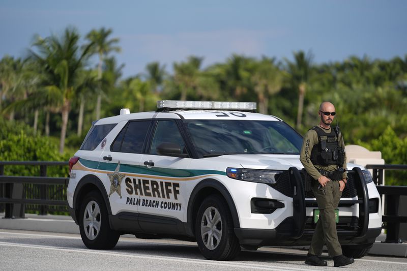 Police stand watch along a road leading to the Mar-a-Lago estate of Republican presidential nominee and former President Donald Trump, one day after an apparent assassination attempt, in Palm Beach, Fla., Monday, Sept. 16, 2024. (AP Photo/Rebecca Blackwell)