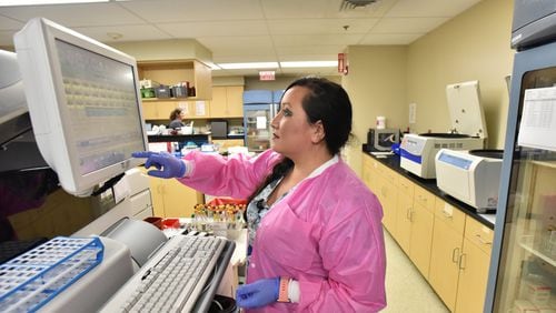 Tammy Potts operates a testing device in a laboratory at Wayne Memorial Hospital in Jesup. Wayne Memorial has to treat all comers, whether they can pay or not, and they’re concerned about private profit-making businesses cherry-picking the profitable procedures and leaving public hospitals to fail. Photo by HYOSUB SHIN / HSHIN@AJC.COM