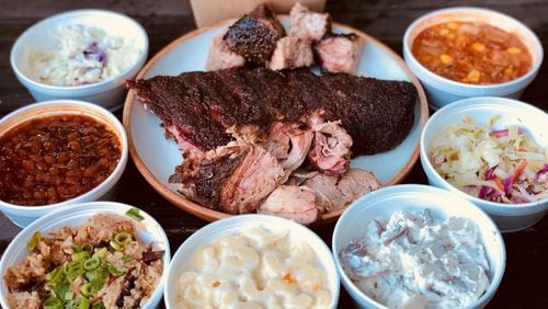 Takeout from Taylor’d Bar-B-Q includes brisket, ribs, pulled pork, plus all the fixings (clockwise from top): tots, Brunswick stew, vinegar slaw, potato salad, mac and cheese, Jambalaya Que, baked beans and creamy cole slaw. CONTRIBUTED BY WENDELL BROCK