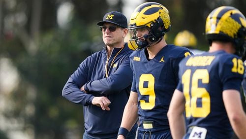 Michigan head coach Jim Harbaugh, left, stands near quarterbacks J.J. McCarthy (9) and Davis Warren (16) during NCAA college football practice Friday, Dec. 29, 2023, in Carson, Calif. Michigan is scheduled to play against Alabama on New Year's Day in the Rose Bowl, a semifinal in the College Football Playoff. (AP Photo/Ryan Sun)