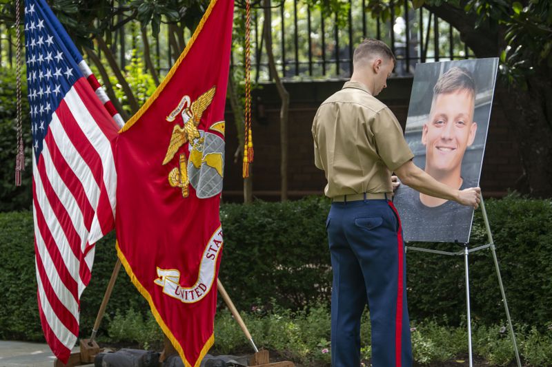 A marine places a photo of Cpl. Spencer Collart on an easel before a ceremony where he is posthumously awarded the Navy and Marine Corps medal on Monday, Sept. 16, 2024 in Washington. Cpl. (AP Photo/Kevin Wolf)