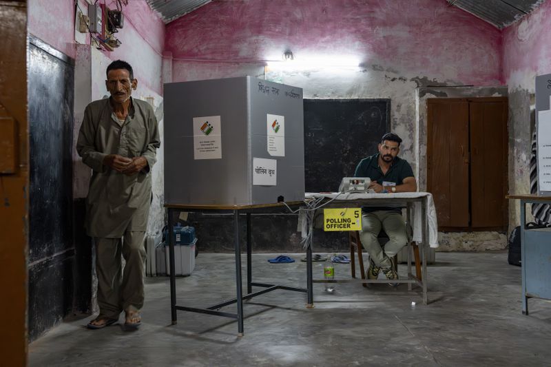 A polling official looks on as a man leaves after casting his vote in the seventh and last round of polling in India's national election in Dharamshala, Saturday, June 1, 2024. (AP Photo/Ashwini Bhatia)
