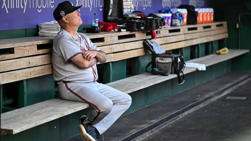 Atlanta Braves manager Brian Snitker sits alone in the dugout before a baseball game against the Washington Nationals, Wednesday, Sept. 11, 2024, in Washington. The Braves lost 5-1. (AP Photo/John McDonnell)