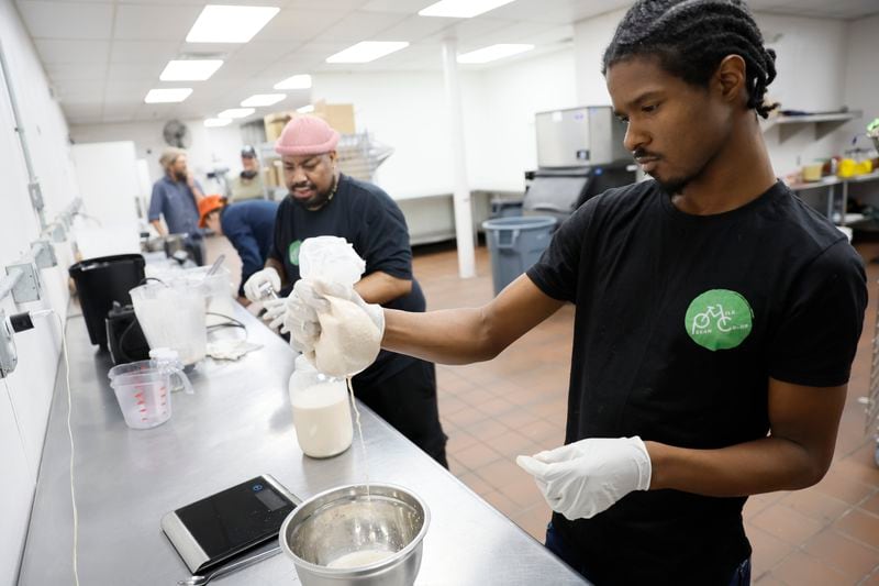 Nijil Jones works filtering the pecan milk while Antonio Little prepares the containers for the handmade pecan milk; they are part of a cooperative where six employees are owners of the company.
Thursday, April 13, 2023.

Miguel Martinez /miguel.martinezjimenez@ajc.com