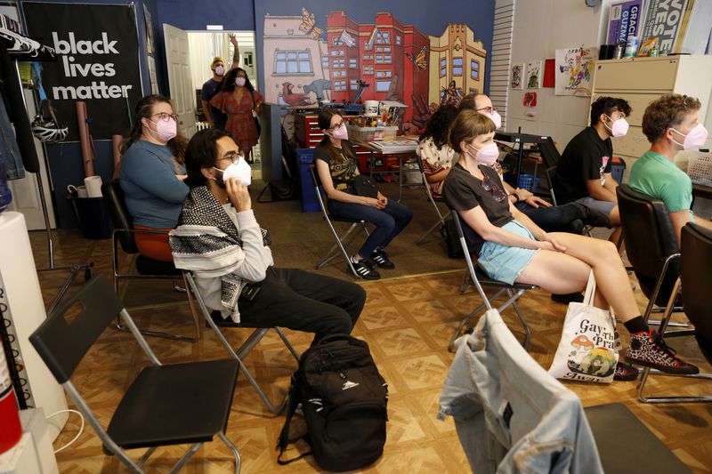 YM Masood, second from left, listens during a March on DNC planning meeting Sunday, Aug. 11, 2024, at the office of Chicago Alderwoman Rossana Rodríguez Sanchez, standing in the back doorway in red. The group talked about ways to stay safe and get legal help, if needed, at protests. (AP Photo/Martha Irvine)