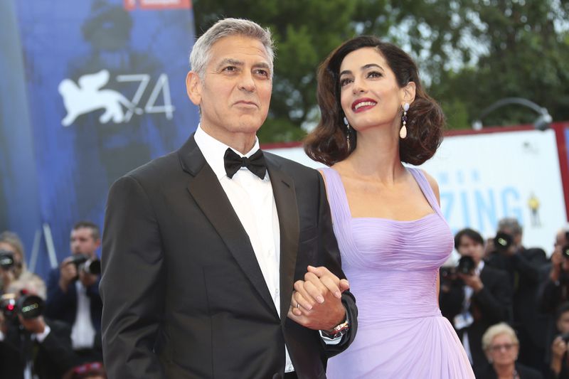 FILE - George Clooney, left, and Amal Clooney appear at the premiere of the film "Suburbicon" during the 74th edition of the Venice Film Festival in Venice, Italy on Sept. 2, 2017. (Photo by Joel Ryan/Invision/AP, File)