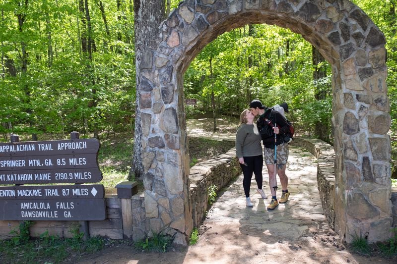 Zach Cross kisses his wife Grayson as they walk through the arch at the beginning of the approach trail to the Appalachian Trail on Monday just before he started his thru-hike.  (Ben Gray / Ben@BenGray.com)