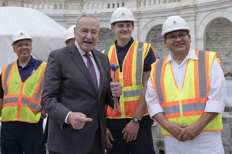 Senate Majority Leader Chuck Schumer, D-N.Y., poses for a photo to the First Nail Ceremony marking the beginning of construction of the 2025 Presidential Inauguration platform, on the steps of the Capitol, Wednesday, Sept. 18, 2024, in Washington. (AP Photo/Mariam Zuhaib)