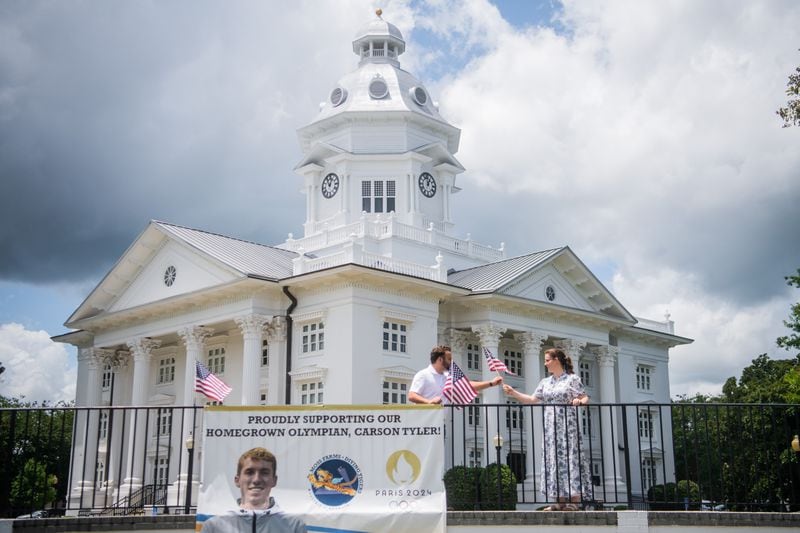 Main Street Manager of City of Moultrie Bolt VanDalsem and Executive Director of Moultrie Convention and Visitor Bureau Caroline Barber zip tie American flags on a Carson Tyler poster in front of Colquitt County Courthouse in Moultrie on Wednesday, July 24, 2024.  (Ziyu Julian Zhu / AJC)