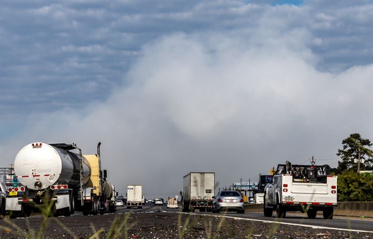 Westbound traffic on I-20 approach the plume of smoke rising from BioLab that continued on Thursday, Oct. 3, 2024 in Conyers. A Sunday fire at the chemical plant in Conyers has had agencies monitoring the air quality since then as crews try to neutralize the site. Rockdale County officials said that the plume is changing colors as workers remove debris. GEMA has advised anyone who notices a chlorine odor in the air to limit their time outdoors. (John Spink/AJC)