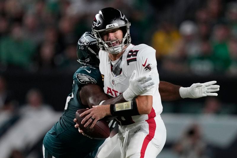 Atlanta Falcons quarterback Kirk Cousins is stopped by Philadelphia Eagles defensive end Brandon Graham (55) during the first half of an NFL football game Monday, Sept. 16, 2024, in Philadelphia. (AP Photo/Matt Rourke)