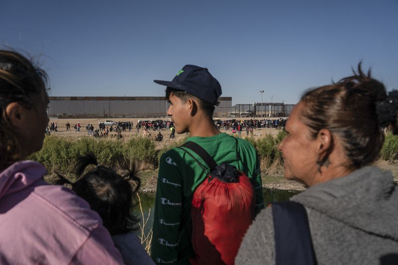 Seen from Ciudad Juarez, Mexico: asylum-seeking migrants mostly from Venezuela apprehended by U.S. Border Patrol and U.S. National Guards after crossing the Rio Grande into the U.S., on March 29, 2023. The Biden administration will start deporting Venezuelans who crossed into the country illegally, officials said Thursday, Oct. 5, 2023, in its latest attempt to stem the pace of migrants fleeing the humanitarian crisis in that country. (Go Nakamura/The New York Times)