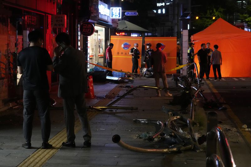 Police officers control a car accident scene near Seoul City Hall in downtown Seoul, South Korea, Monday, July 1, 2024. A car slammed into pedestrians in central Seoul on Monday night, killing nine people and injuring four others, officials said. (AP Photo/Ahn Young-joon)