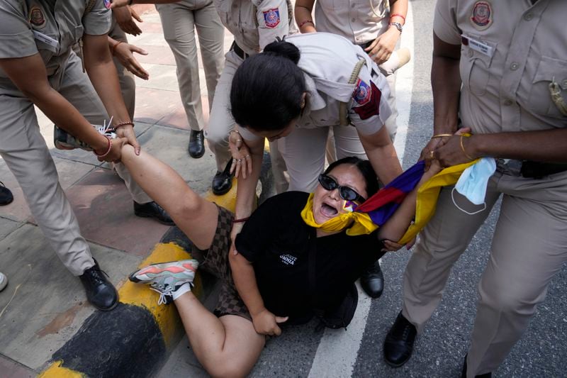 Policewomen detain an exile Tibetan protesting against the human rights situation in Tibet during a protest to coincide China marking its 75th year of Communist Party rule, outside Chinese embassy, in New Delhi, India, Tuesday, Oct. 1, 2024. (AP Photo/Manish Swarup)