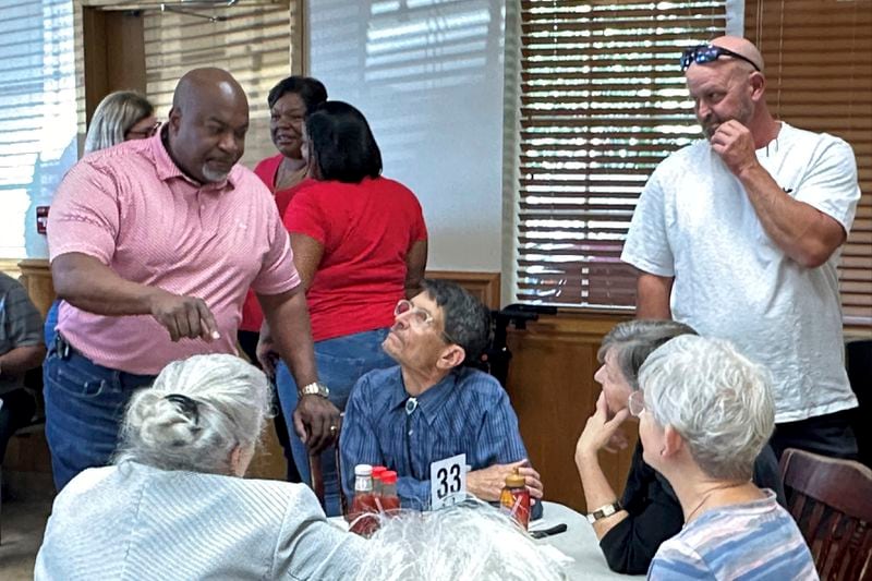 North Carolina Republican gubernatorial candidate Mark Robinson, left, speaks with patrons at the Olympic Family Restaurant in Colfax, N.C., where Robinson held a campaign event on Monday, Aug. 26, 2024. (AP Photo/Gary D. Robertson).