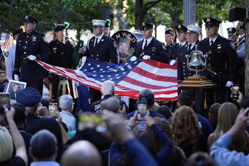 A New York Police Department honor guard holds an American flag during a 9/11 commemoration ceremony at Ground Zero, in New York, Wednesday, Sept. 11, 2024. (AP Photo/Jacquelyn Martin)