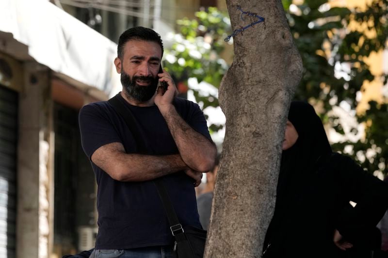 A man reacts as he speaks on the phone near the site of Friday's Israeli strike in Beirut's southern suburbs, Saturday, Sept. 21, 2024. (AP Photo/Bilal Hussein)