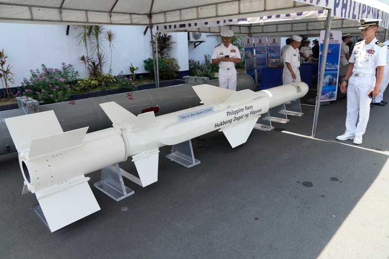 A Philippine Navy officer poses beside a ship to ship missile (CSTAR) that is displayed during the 126th Philippine Navy anniversary in Manila, Philippines on Friday, May 24, 2024. The Philippines would press efforts to build security alliances and stage realistic combat drills, including joint naval sails with the United States, Japan and Australia in disputed waters, to defend its territorial interests, Defense Secretary Gilberto Teodoro said Friday, dismissing China's criticisms of such moves as a sign of paranoia. (AP Photo/Aaron Favila)