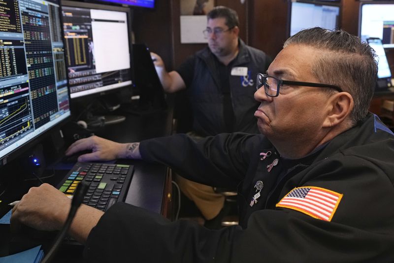 Trader Jonathan Mueller, foreground, works on the floor of the New York Stock Exchange, Friday, Aug. 16, 2024. (AP Photo/Richard Drew)