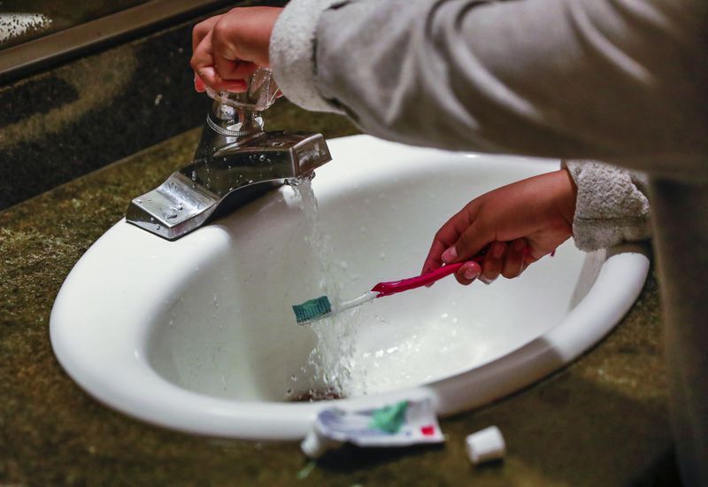 FILE - A child rinses a toothbrush in San Francisco on June 18, 2019. (Gabrielle Lurie/San Francisco Chronicle via AP, File)