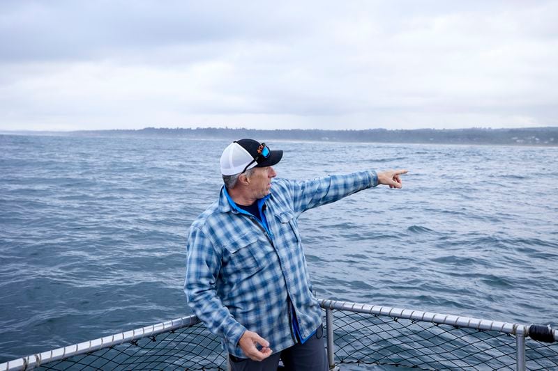 Burke Hales, chief scientist for the PacWave wave energy test site overseen by Oregon State University, points to the area along the beach where electric cables buried under the seabed come to the shore near Newport, Ore., Friday, Aug. 23, 2024. (AP Photo/Craig Mitchelldyer)