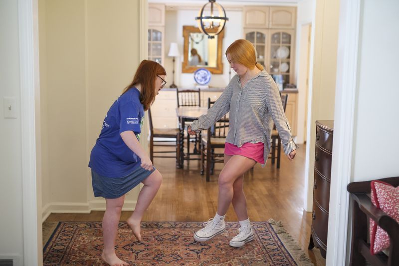 Darden, 18, dances with her younger sister Anna, 16, at their home. (Jason Getz / Jason.Getz@ajc.com)