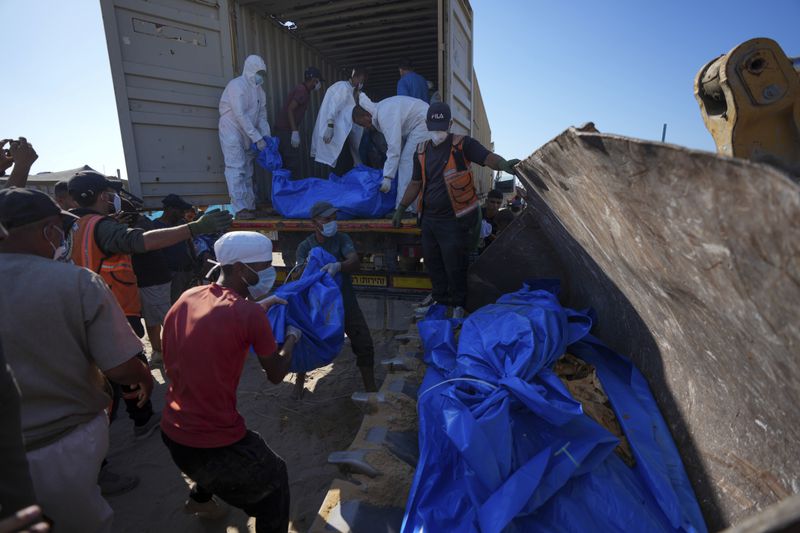 People bury the bodies of Palestinians taken by the Israeli military during operations in Gaza and returned this week, in Khan Younis, Gaza Strip, Thursday, Sept. 26, 2024. (AP Photo/Abdel Kareem Hana)