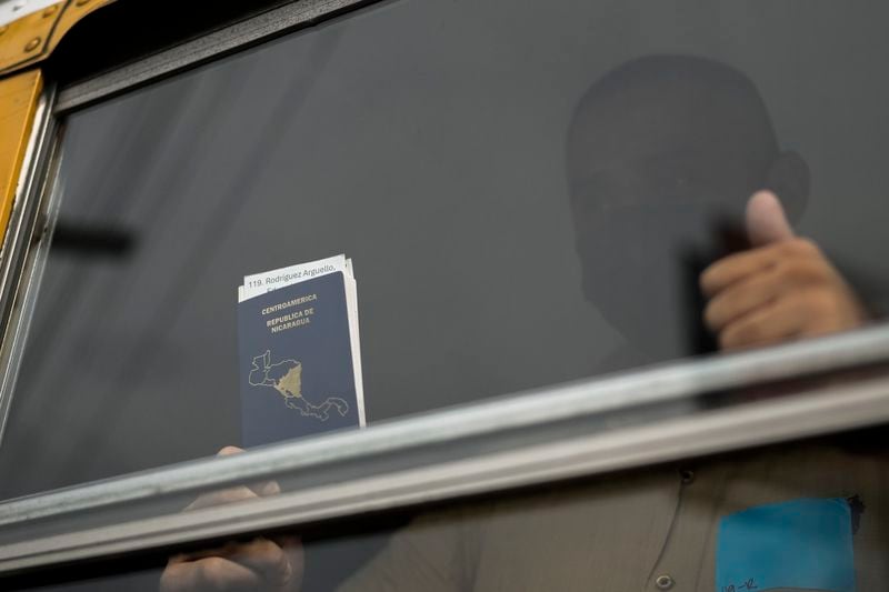 A Nicaraguan citizen shows his passport from a bus after being released from a Nicaraguan jail and landing at the airport in Guatemala City, Thursday, Sept. 5, 2024. (AP Photo/Moises Castillo)