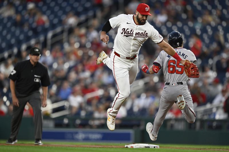 Washington Nationals first baseman Joey Gallo, center, cannot tag Atlanta Braves' Luke Williams on a throwing error during the third inning of a baseball game, Tuesday, Sept. 10, 2024, in Washington. (AP Photo/John McDonnell)