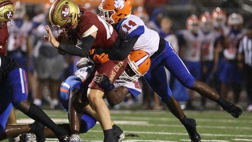 081722 Johns Creek, Ga.: Johns Creek quarterback Michael McClellan (12) is tackled by Parkview linebacker Nolan Marshall (22) and defensive back Terrence Curtis (14, right) during their game at Johns Creek high school Wednesday, August 17, 2022, in Johns Creek, Ga. Parkview won 52-7. (Jason Getz / Jason.Getz@ajc.com)