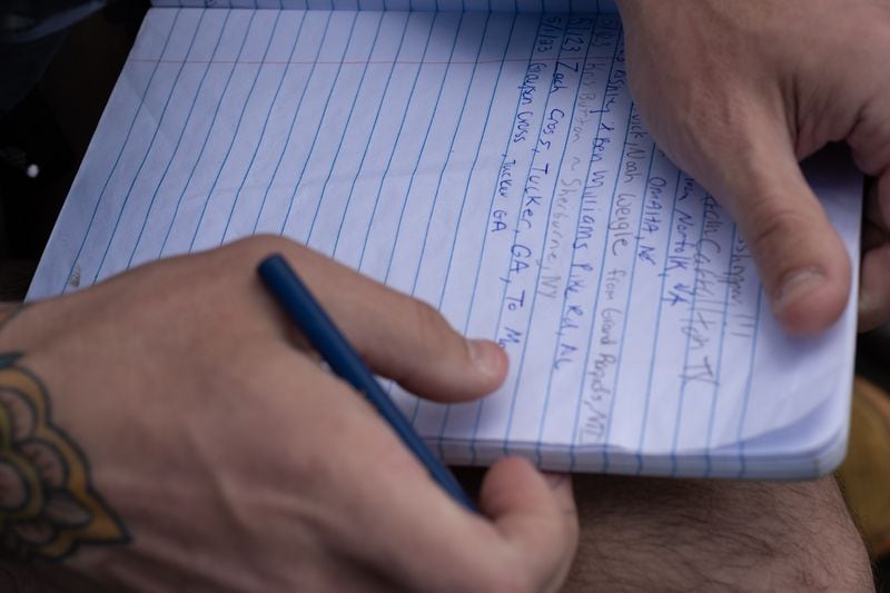 Zach Cross sits at the Southern terminus of the Appalachian Trail and writes in a log book for hikers on Monday just before he started his Appalachian Trail thru-hike.  (Ben Gray / Ben@BenGray.com)