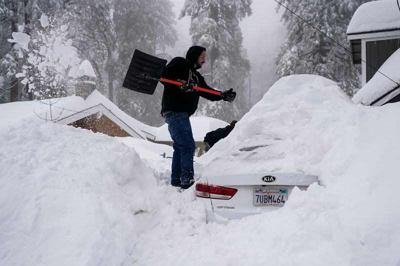 FILE - Kenny Rybak shovels snow around his car in Running Springs, Calif., Tuesday, Feb. 28, 2023. (AP Photo/Jae C. Hong, File)