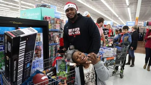 FILE: Grady Jarrett, an Atlanta Falcons football player, helps a youngster shop for toys. (Courtesy of Grady Jarrett/Facebook)