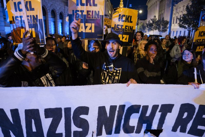 Anti right wing protesters shout slogans holding a banner that reads "Don't let Nazis rule and never let them march" near the parliament building, in Vienna, Austria, Sunday, Sept. 29, 2024, after polls closed in the country's national election. (AP Photo/Andreea Alexandru)