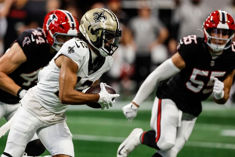 New Orleans Saints wide receiver Chris Olave (12) runs against Atlanta Falcons linebacker Kaden Elliss (55) during the first half of an NFL football game, Sunday, Sept. 29, 2024, in Atlanta. (AP Photo/Butch Dill)