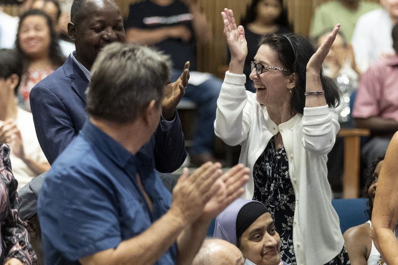 Some of the 150 participants stand and celebrate when their country is being called during the naturalization ceremony at the Gwinnett Justice Administration Center Tuesday July 2 2024. (Steve Schaefer / AJC)