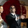 FILE - Sean "P. Diddy" Combs directs photographers as they sing "Happy Birthday," to him as his date Kim Porter, left, listens, after Combs arrived for his 35th birthday celebration at Cipriani on Wall Street in New York, Nov. 4, 2004. (AP Photo/Kathy Willens, File)