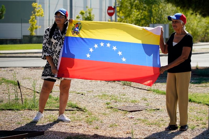 Supporters of Edmundo González wait for his arrival outside the Torrejón Air Base in Madrid, Spain, Sunday, Sept. 8, 2024. Former Venezuelan opposition presidential candidate Edmundo González has fled into exile after being granted asylum in Spain, delivering a major blow to millions who placed their hopes in his upstart campaign to end two decades of single-party rule. (AP Photo/Andrea Comas)