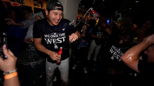 Los Angeles Dodgers designated hitter Shohei Ohtani celebrates with teammates after the Dodgers defeated the San Diego Padres 7-2 in a baseball game to clinch the National League West division Thursday, Sept. 26, 2024, in Los Angeles. (AP Photo/Ashley Landis)