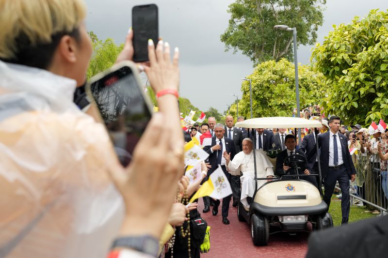 Pope Francis travels in a buggy as he greets the volunteers on his arrival in Singapore, Wednesday, Sept. 11, 2024. (AP Photo/Vincent Thian)