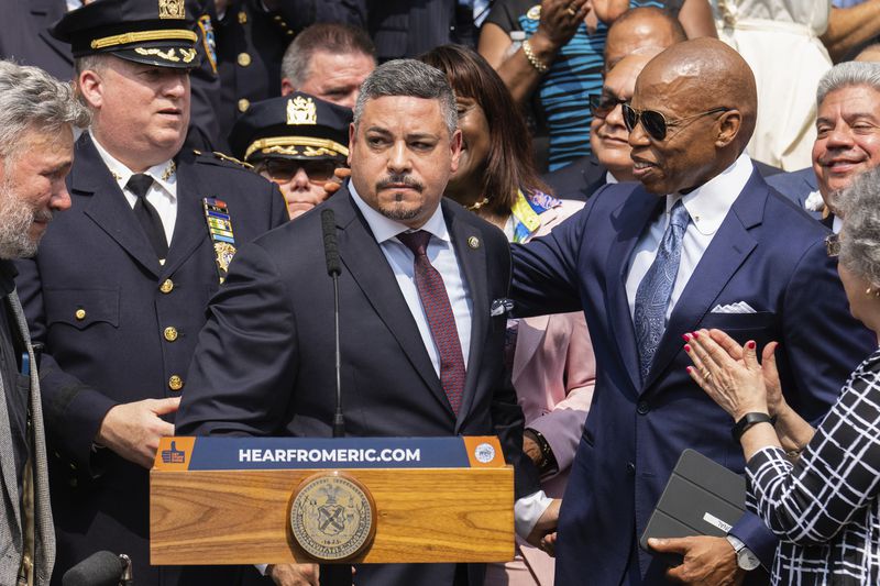 FILE - Edward A. Caban, center, speaks after being sworn in as NYPD police commissioner outside New York City Police Department 40th Precinct on Monday, July 17, 2023, in New York. Mayor Eric Adams on the right. (AP Photo/Jeenah Moon, File)