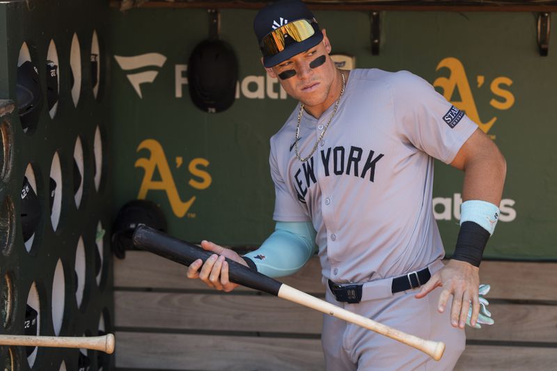 New York Yankees' Aaron Judge grabs a bat from the dugout before a baseball game against the Oakland Athletics in Oakland, Calif., Sunday, Sept. 22, 2024. (AP Photo/Nic Coury)