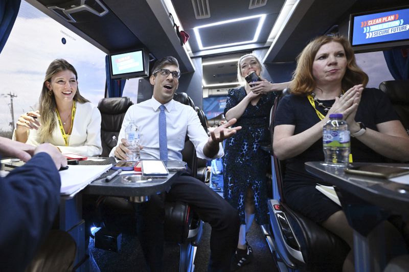 FILE - Britain's Prime Minister Rishi Sunak speaks to journalists on the campaign bus following the launch of the Welsh Conservatives General Election manifesto near Rhyl, Wales, England, Friday June 21, 2024. Luxury coaches known as Battle Buses are rented by the main political parties to whisk politicians and journalists around the country for campaign visits during the five-week campaign. (Leon Neal/Pool Photo via AP, File)